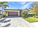 Charming single-story home featuring a well-manicured lawn, palm trees, and a two-car garage with a paved driveway at 1849 E Isles Rd, Port Charlotte, FL 33953