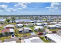 Scenic aerial view of a residential community with homes nestled around a tranquil lake under a sunny sky at 215 Schooner St, North Port, FL 34287