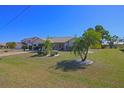 Charming home features a well-maintained lawn with tropical landscaping and a two-car garage at 32 Bariloche Dr, Punta Gorda, FL 33983