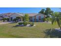 Charming home features a well-maintained lawn with tropical landscaping and a two-car garage at 32 Bariloche Dr, Punta Gorda, FL 33983