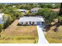 A charming single-story home with a light-colored exterior, large front yard, and a canal view in the backyard at 3436 Discovery Dr, Punta Gorda, FL 33983