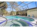 Inviting screened-in pool with a spa and outdoor seating area for entertaining at 3956 Fairchild Ave, North Port, FL 34287