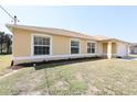 Inviting single-story home with tan siding, white trim, and a well-manicured lawn at 4237 Irdell Ter, North Port, FL 34288