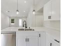 Modern kitchen featuring a central island with stainless steel sink and white cabinets at 4517 Meager Cir, Port Charlotte, FL 33948