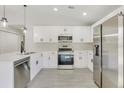 Bright kitchen featuring white cabinets, stainless steel appliances, and island seating at 4517 Meager Cir, Port Charlotte, FL 33948