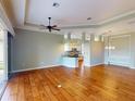 Spacious living area with hardwood floors, ceiling fan, and open layout to the modern kitchen at 629 Misty Pine Dr, Venice, FL 34292