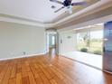 Open living space with hardwood floors, ceiling fan, and sliding glass doors leading to the lanai at 629 Misty Pine Dr, Venice, FL 34292