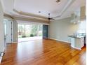 Bright living room featuring hardwood floors, ceiling fan, and sliding glass doors to the outdoor patio at 629 Misty Pine Dr, Venice, FL 34292
