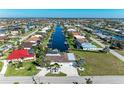 Aerial shot shows home along a canal in a waterfront community with lush greenery and boats docked behind many properties at 740 Via Esplanade, Punta Gorda, FL 33950