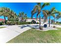 Well-maintained home with a spacious driveway, manicured landscaping, and mature palm trees at 740 Via Esplanade, Punta Gorda, FL 33950