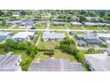 An aerial view captures a home with a spacious backyard in a charming neighborhood surrounded by lush greenery at 858 Conreid Ne Dr, Port Charlotte, FL 33952