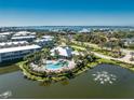 Aerial view of a large pool and lounge area surrounded by mature landscaping and a pond at 10300 Tarpon Landings Ter # 4, Placida, FL 33946