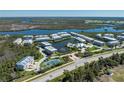 An aerial view of the townhouses near a lake, with community tennis courts at 10300 Tarpon Landings Ter # 4, Placida, FL 33946