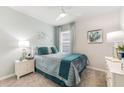 Stylish bedroom with a comfortable bed, fan, carpet, and coordinating décor in a refreshing color palette at 12141 Karney Ave, Port Charlotte, FL 33981