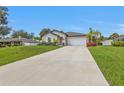 Beautifully landscaped home with a wide driveway leading to an attached two-car garage at 1353 Newton St, Port Charlotte, FL 33952