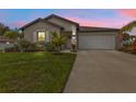 Charming home with a well-kept lawn and tropical landscaping at sunset at 1353 Newton St, Port Charlotte, FL 33952