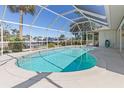 Relaxing screened-in pool area perfect for enjoying sunny days and outdoor entertaining with views of the waterfront at 18486 Briggs Cir, Port Charlotte, FL 33948