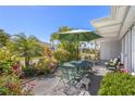 Relaxing patio space with an outdoor table set, surrounded by lush landscaping, perfect for outdoor dining at 196 The Corso # 196, Venice, FL 34285