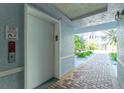 Condominium hallway with access to elevator, outdoor seating, and lush landscaping at 2001 Bal Harbor Blvd # 2202, Punta Gorda, FL 33950