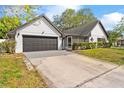 View of the home's driveway and two-car garage, accented with beautiful landscaping at 2027 59Th N St, Clearwater, FL 33760