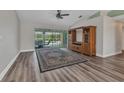 Bright living room with sliding glass doors to the pool area, wood-look floors, and a ceiling fan at 23531 Dunstan Ave, Port Charlotte, FL 33954