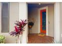 Inviting entryway with a vibrant orange door and decorative wall art at 2436 Arugula Dr, North Port, FL 34289