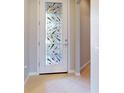 Bright foyer featuring a decorative glass door and neutral tile flooring at 2436 Arugula Dr, North Port, FL 34289