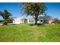 A serene single-story home with a two-car garage and lush green lawn, under a clear blue sky at 27250 Salta Dr, Punta Gorda, FL 33983