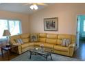 Comfortable living room with a large yellow sectional, area rug, and a relaxing ambiance at 293 Broadmoor Ln, Rotonda West, FL 33947