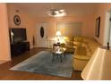 Cozy living room with a plush yellow sectional, hardwood floors, and a bright, inviting atmosphere at 293 Broadmoor Ln, Rotonda West, FL 33947