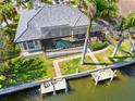 Aerial view of the waterfront home featuring a pool, dock, and lush tropical landscaping at 3812 Carupano Ct, Punta Gorda, FL 33950