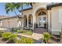 Elegant home featuring a beautiful arched entrance, columns, and meticulously landscaped garden at 3812 Carupano Ct, Punta Gorda, FL 33950