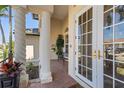 Covered front porch with brick pavers and decorative columns leads to a glass front door at 3812 Carupano Ct, Punta Gorda, FL 33950