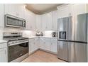 Modern kitchen featuring stainless steel appliances and sleek white cabinets at 43914 Blue Heron Ln, Punta Gorda, FL 33982