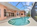 Inviting covered outdoor pool with a unique shape and elegant design featuring tile accents and clear enclosure at 480 Macedonia Dr, Punta Gorda, FL 33950