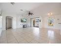 Spacious living room with tile flooring, ceiling fan, and sliding glass doors leading to the outdoor at 7014 Baylor Street, Englewood, FL 34224