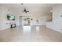 Bright living room featuring vaulted ceilings, tile flooring, and access to the backyard at 7014 Baylor Street, Englewood, FL 34224