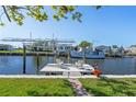 Backyard canal view featuring boat dock with boat lift and chairs for enjoying waterfront living at 721 Dania Ct, Punta Gorda, FL 33950
