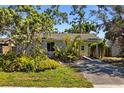 Inviting single-story home with mature trees, lush plants, and a private driveway for a tranquil setting at 1060 Venetian Pkwy, Venice, FL 34285