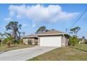Well-maintained one-story home with an attached two-car garage and a long driveway at 121 Long Meadow Ln, Rotonda West, FL 33947