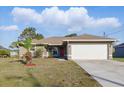 Attractive one-story home featuring a red front door, and a two-car garage at 121 Long Meadow Ln, Rotonda West, FL 33947