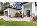Close up of front entrance with craftsman front door, stone accents, and paver walkway at 1384 Alpinia Rd, North Port, FL 34288