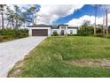 A charming home with a well-manicured lawn and a paved driveway leading to a two-car garage at 1384 Alpinia Rd, North Port, FL 34288