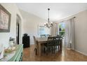 Well-lit dining room featuring rustic table with seating, elegant chandelier, and large window at 1406 Woodcrest, North Port, FL 34286