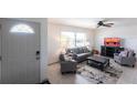 Bright living room featuring modern furniture, a ceiling fan, and plenty of natural light from large windows at 1516 Saint Clair Rd, Englewood, FL 34223