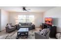 Comfortable living room with neutral tones, tile flooring, and bright natural light from the large window at 1516 Saint Clair Rd, Englewood, FL 34223