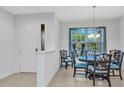 Bright dining room featuring a chandelier and large window, next to a foyer at 1808 Kings Gate Ct, Punta Gorda, FL 33980