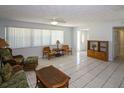 Spacious living room featuring tile flooring, natural lighting, and comfortable seating arrangement at 22191 New Rochelle Ave, Port Charlotte, FL 33952