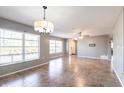 Open living room area featuring tile floors, neutral paint, ceiling fan, and multiple windows for lots of light at 23179 Maclellan Ave, Port Charlotte, FL 33980