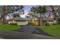 Charming home at dusk with tile roof, attached garage, curved driveway, and beautiful landscaping at 238 Southampton Dr # 319, Venice, FL 34293